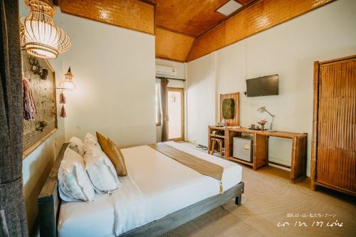 a bedroom with a bed and a television in it at บ่อเกลือ วิว รีสอร์ท in Ban Pha Khap