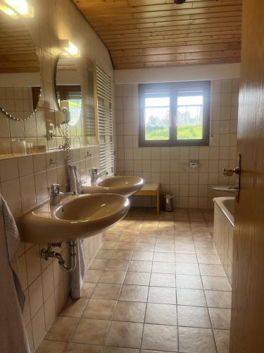 a bathroom with two sinks and a window at Breighof in Biberach bei Offenburg