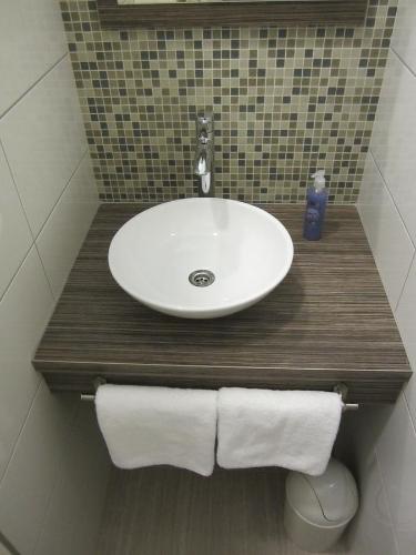 a bathroom sink with two towels on a wooden counter at Aurelia Rooms in Mostar