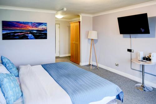 a bedroom with a bed and a flat screen tv at Warwickshire Park Hotel Kenilworth by Belvilla in Kenilworth