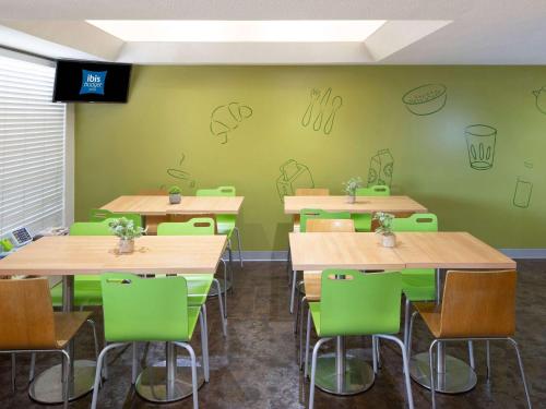 a classroom with tables and chairs with drawings on the wall at ibis Budget - Campbelltown in Campbelltown