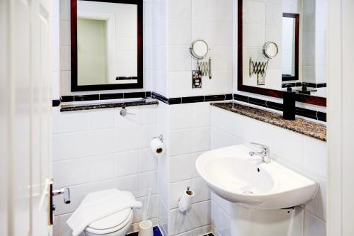 a white bathroom with a sink and a toilet at Warwickshire Park Hotel Kenilworth by Belvilla in Kenilworth