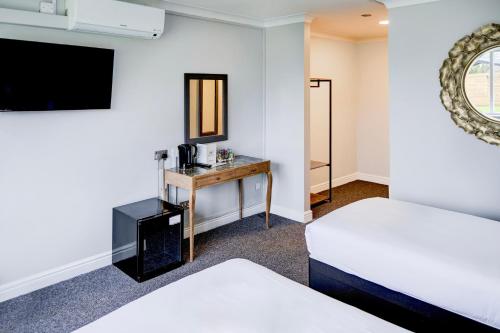 a hotel room with two beds and a desk at Warwickshire Park Hotel Kenilworth by Belvilla in Kenilworth