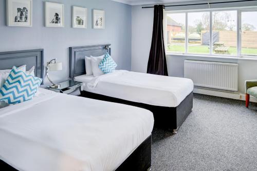 a bedroom with two beds and a window at Warwickshire Park Hotel Kenilworth by Belvilla in Kenilworth