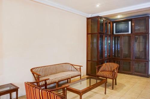 a living room with chairs and a table and a tv at Collection O Peunayong Near Masjid Raya Baiturrahman Formerly Siwah Hotel in Banda Aceh