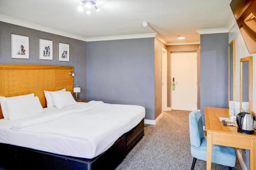 a hotel room with a bed and a desk and a bed at Warwickshire Park Hotel Kenilworth by Belvilla in Kenilworth