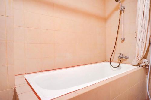 a white bath tub in a bathroom with a shower at Collection O Peunayong Near Masjid Raya Baiturrahman Formerly Siwah Hotel in Banda Aceh