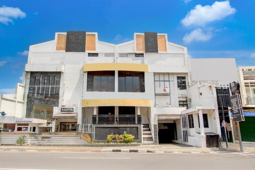 a white building on the corner of a street at Collection O Simpang Lima Near Simpang Lima Semarang Formerly Hotel Eben Haezer in Semarang