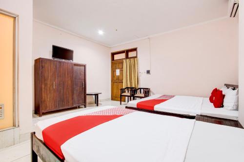 a bedroom with two beds and a tv at Collection O Simpang Lima Near Simpang Lima Semarang Formerly Hotel Eben Haezer in Semarang