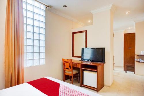 a bedroom with a desk with a television and a bed at Collection O Peunayong Near Masjid Raya Baiturrahman Formerly Siwah Hotel in Banda Aceh