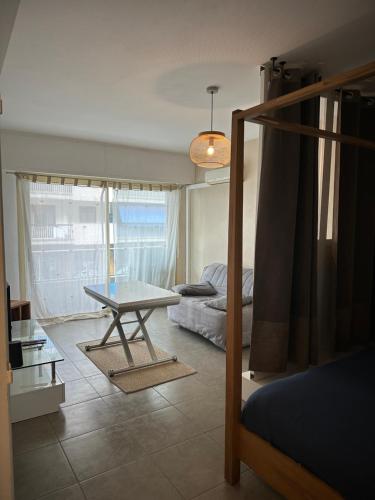 un salon avec une table et un lit dans l'établissement Grand Studio avec Coin Nuit et Parking, à Saint-Laurent-du-Var
