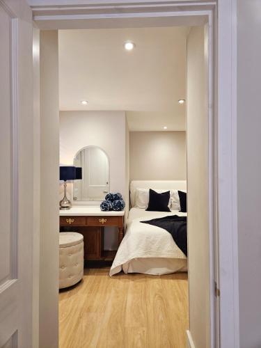 a bedroom with a bed and a desk with a mirror at The Grieg in Wadhurst