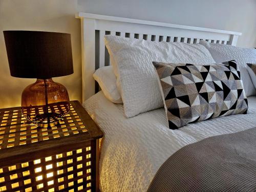 a bedroom with a bed with a table with a lamp at The Lodge in Wadhurst