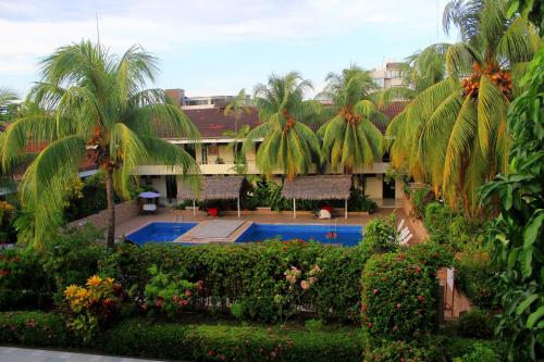an aerial view of a resort with a swimming pool and palm trees at Hotel Sol del Oriente Pucallpa in Pucallpa
