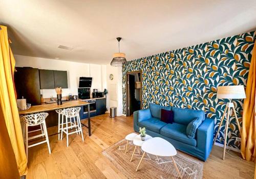 a living room with a blue couch and a kitchen at White House - THE SUNNY avec TERRASSE et PARKING privé - 20 min CENTRE in Amiens