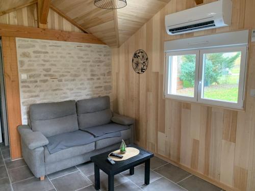 a living room with a couch and a table at Gîte des Lauriers 10 min Zoo de Beauval in Couffy