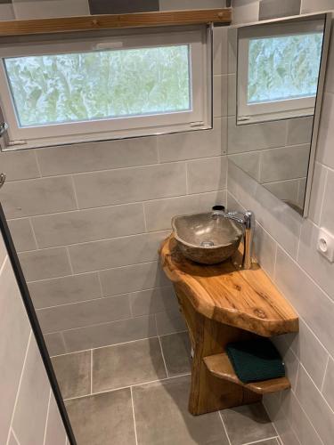 a bathroom with a sink on a wooden table at Gîte des Lauriers 10 min Zoo de Beauval in Couffy