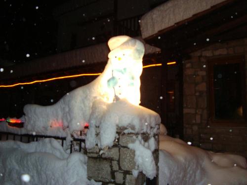 a snow man statue in the snow at night at Hotel Antigoni in Neochori
