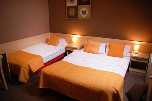 two beds in a hotel room with two lamps at Chata Skrzata in Kruszyn