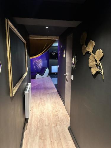 a hallway with a room with purple walls and wooden floors at Le studio secret in Saint Die