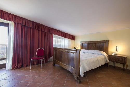 a bedroom with a large bed and a pink chair at The Life in Marcellina