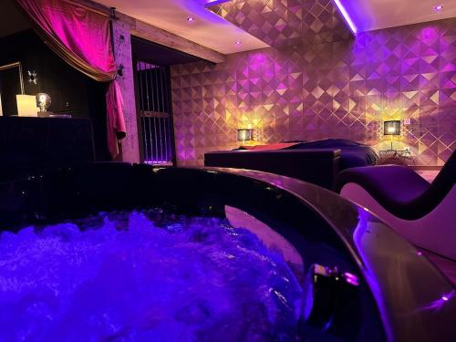 a spa room with a tub with purple lights at Le studio secret in Saint Die