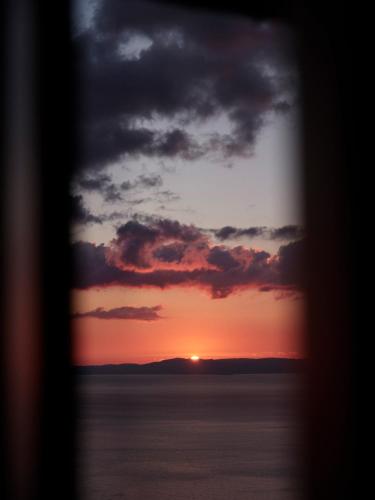a view of a sunset through a window at Rubeas Towers - Pyrgos Towers Complex in Pírgos
