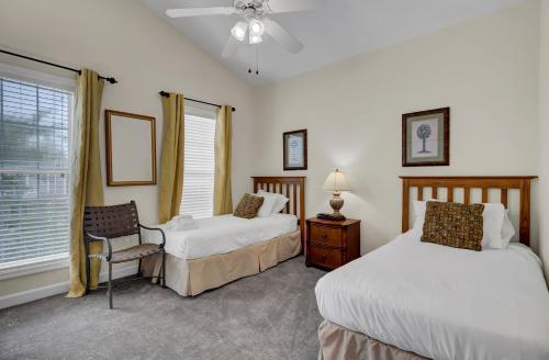 a bedroom with two beds and a chair and a window at Grand Pavilion 29 by Wild Dunes in Isle of Palms