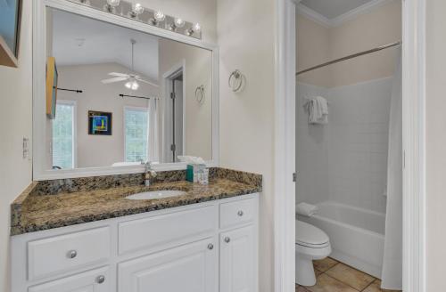 a bathroom with a sink and a toilet and a mirror at Grand Pavilion 29 by Wild Dunes in Isle of Palms