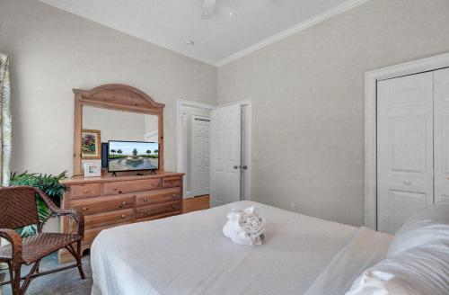 a white cat sitting on a bed in a bedroom at Grand Pavilion 29 by Wild Dunes in Isle of Palms