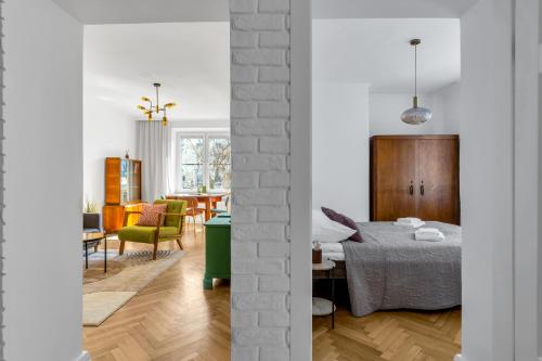 a white room with a bed and a dining room at Wola Ratusz Serene Apartment by BookingHost in Warsaw