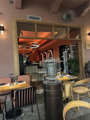 a restaurant with tables and chairs and a bird cage at Madame Hortense Boutique Ηotel in Chania Town
