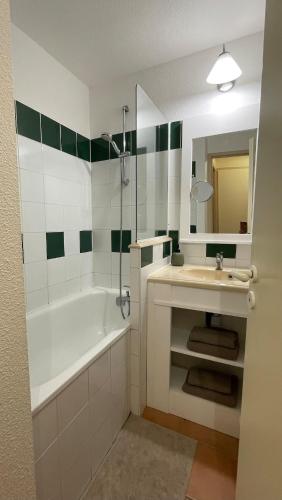 une salle de bain avec une baignoire et un lavabo et une baignoire dans l'établissement Séjour Piscine, Forêt, Océan à Soustons Plage, à Soustons