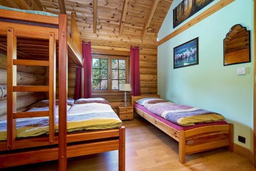 a bedroom with two bunk beds in a log cabin at Ranči v Buši - pokoj ve srubu in Čím
