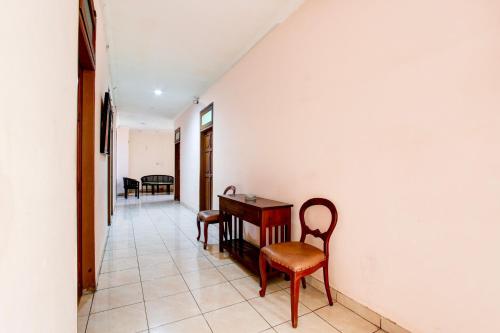 a corridor with a table and chairs in a room at Collection O Simpang Lima Near Simpang Lima Semarang Formerly Hotel Eben Haezer in Semarang