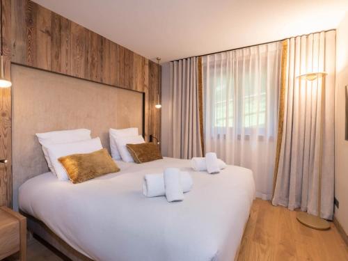 a bedroom with a large white bed with two pillows at Appartement neuf 3 chambres proche des pistes, parking et Wi-Fi - FR-1-565-108 in Les Allues