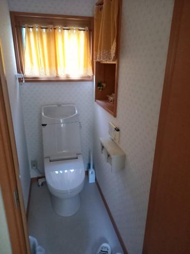 a small bathroom with a toilet and a window at Takumisou 2 in Kiso