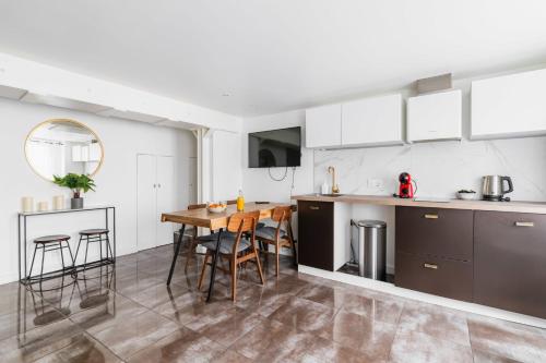 Il comprend une cuisine et une salle à manger avec une table en bois. dans l'établissement 2 pieces Belleville refait neuf 6 pers - paris 19, à Paris