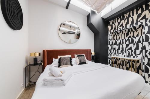 une chambre avec un lit blanc et un miroir dans l'établissement 2 pieces Belleville refait neuf 6 pers - paris 19, à Paris