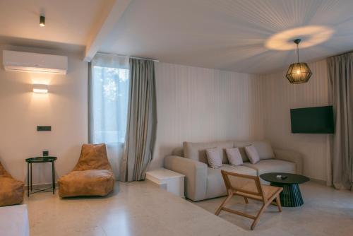 a living room with a couch and a table at Gioma Garden Villas in Istron