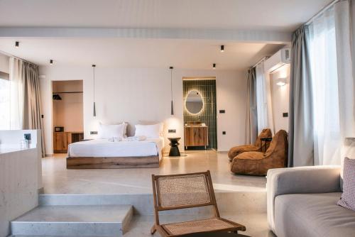 a bedroom with a bed and a chair and a couch at Gioma Garden Villas in Istron
