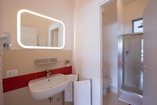 a white bathroom with a sink and a mirror at Levante Residence in La Spezia