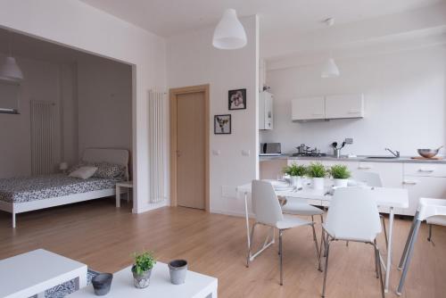 a white kitchen and living room with a table and chairs at Levante Residence in La Spezia
