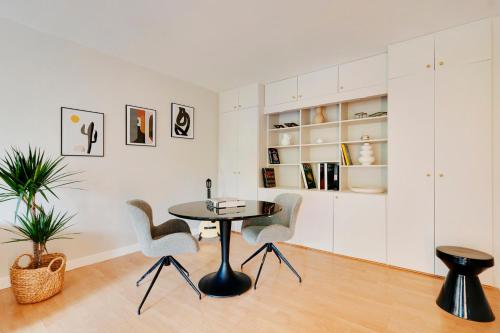 une salle à manger avec une table et des chaises dans l'établissement Spacieux 2 pièces rénové avec terrasse et parking proche La Défense, à Levallois-Perret