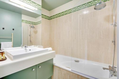 une salle de bain avec un lavabo et une douche dans l'établissement Spacieux 2 pièces rénové avec terrasse et parking proche La Défense, à Levallois-Perret