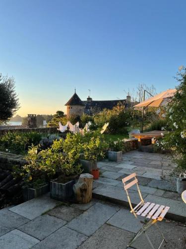 une chaise sur une terrasse avec des plantes et une table dans l'établissement Unique Family House Steps from Port Miquel Beach, à l'Île-aux-Moines