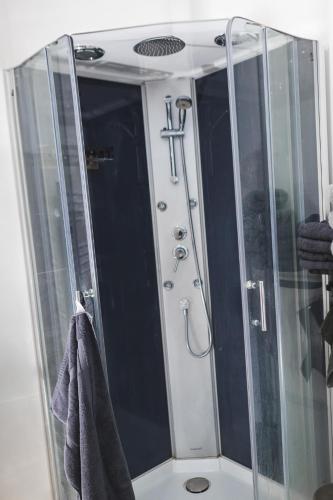 une douche avec une porte vitrée dans une salle de bain dans l'établissement Le petit baigneur, à Étretat