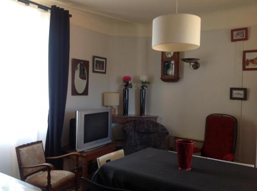 un salon avec une table et une télévision dans l'établissement Ardèche Mas de la châtaigneraie gîtes près de vallon pont d arc, à Gagnières