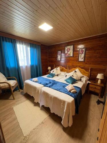 a bedroom with a large bed in a wooden room at La CABAÑA in Candeleda