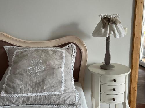 a bed with a pillow and a lamp on a nightstand at Spa&Golf-Suite Velden in Velden am Wörthersee